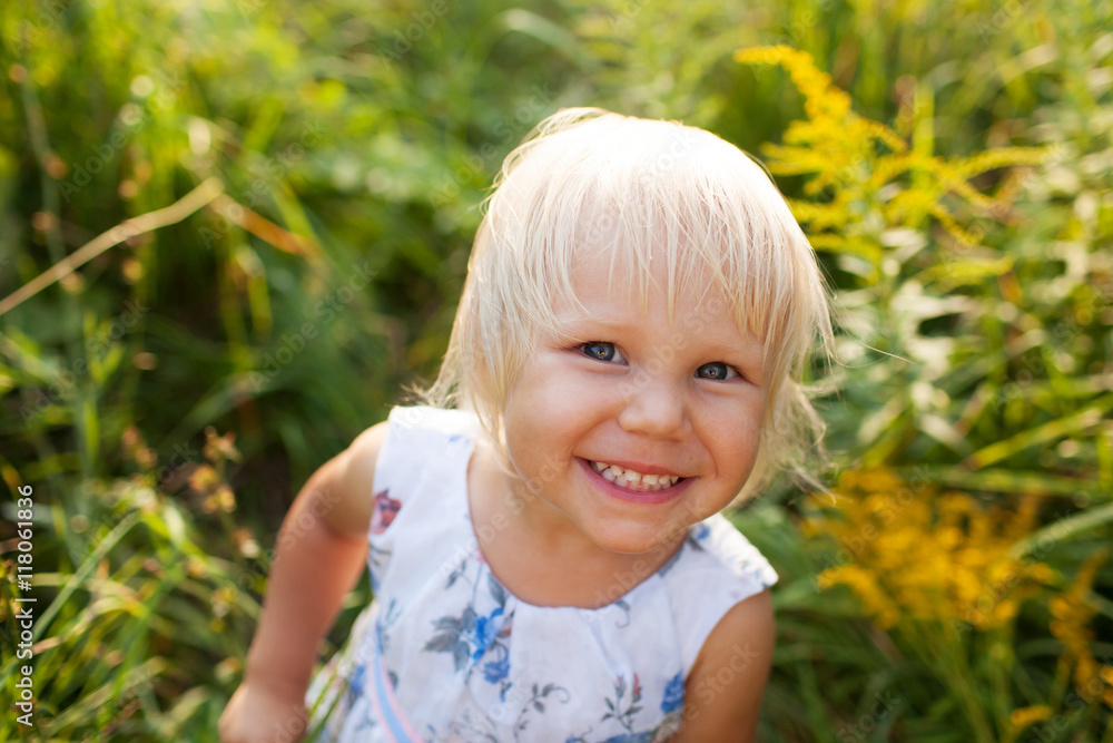 Little girl in summer dress looks into a camera Little girl in summer dress looks into a camera