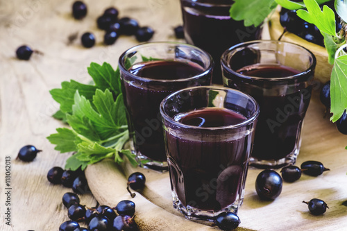 Traditional black currant liqueur in shot glass, selective focus photo