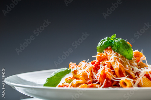 Pasta Penne with Tomato Bolognese Sauce, Parmesan Cheese and Basil Leaves. Mediterranean food.Italian cuisine. photo