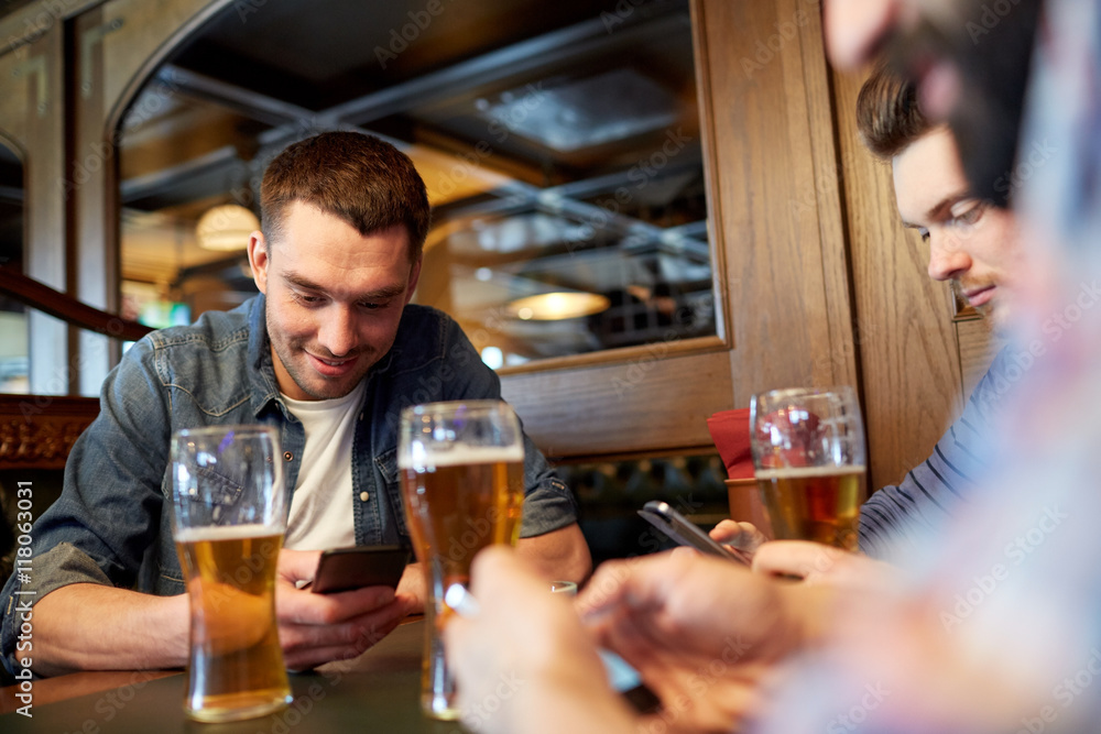 men with smartphones drinking beer at bar or pub