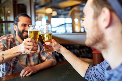 happy male friends drinking beer at bar or pub