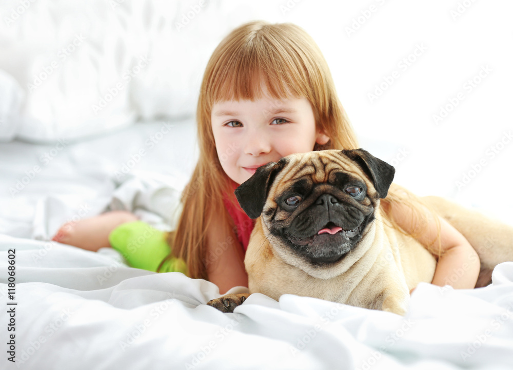 Beautiful girl and cute pug on bed Beautiful girl and cute pug on bed