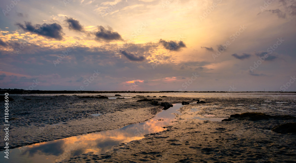 Fototapeta premium Colourful sunrise and stream in low tide ocean water