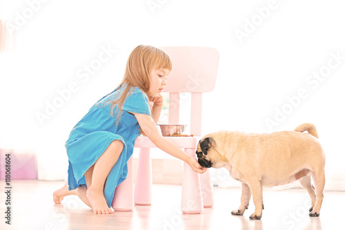 Adorable little girl feedin...