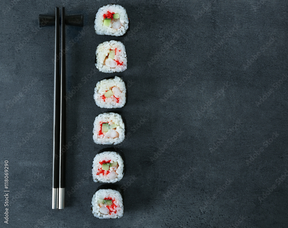 Sushi roll set and chopsticks on dark background Sushi roll set and chopsticks on dark background
