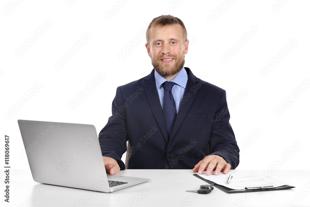 Seller man at table with laptop and car key isolated on white Seller man at table with laptop and car key isolated on white