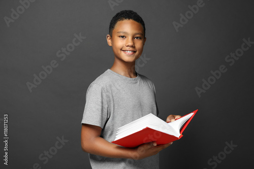 Cute boy reading book on gr...