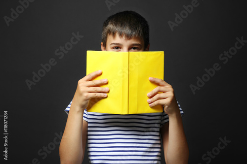Cute boy reading book on gr...