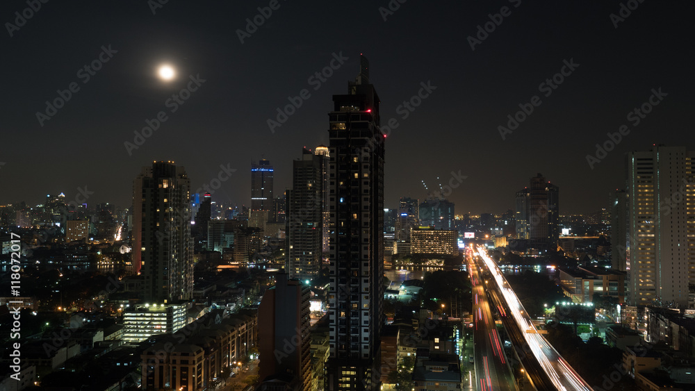 Bangkok panorama at night. View to the illuminated high-rise buildings and skyscrapers with transport traffic on highway. Capital of Thailand
