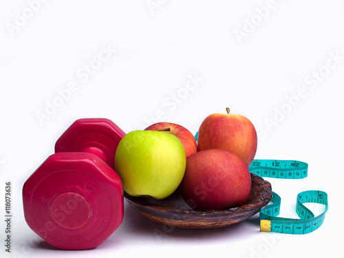 .Red dumbbells weight with measuring tape and apple