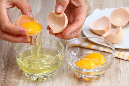 Woman hands breaking egg to separate egg- white &  yolks