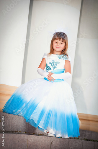 Little bride. A girl in a lush white and blue wedding dress