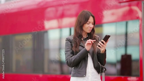 Young woman with luggage taking selfie at a train station. Caucasiam tourist waiting her express train while her traveling. photo