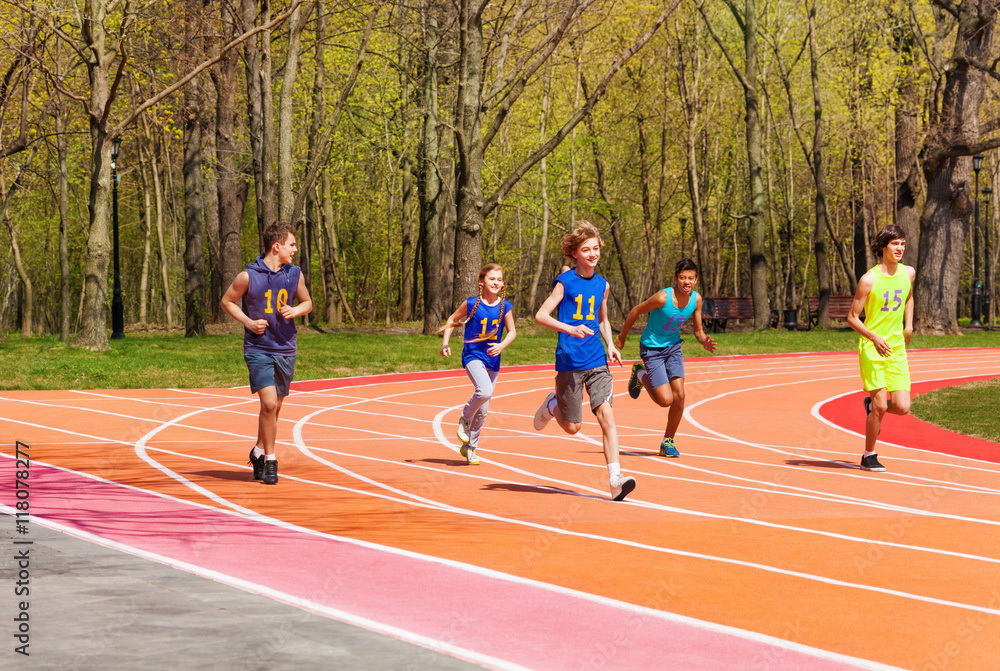Fototapeta premium Five running teenage athletes in the stadium