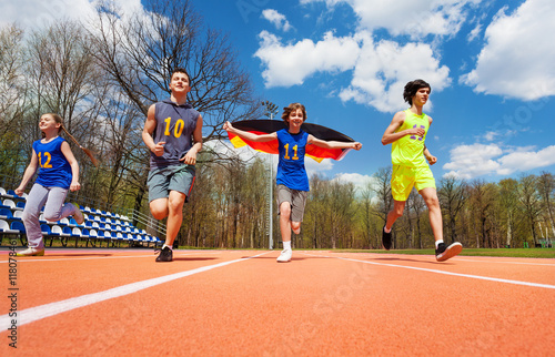 Teenage athletes with German flag running on track © Sergey Novikov