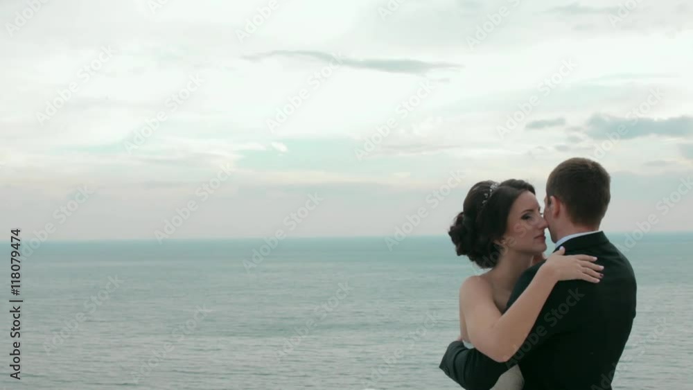 Happy newlyweds embracing near the sea Happy newlyweds embracing near the sea