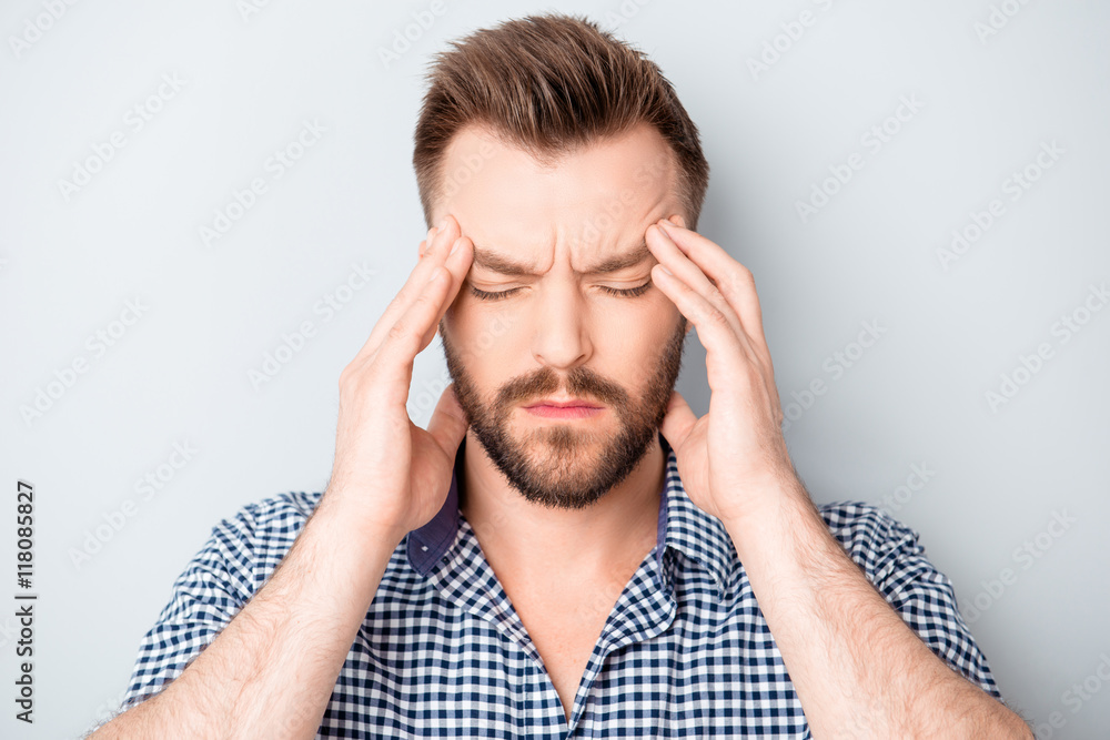 Handsome young man touching his head and feeling strong headache Handsome young man touching his head and feeling strong headache