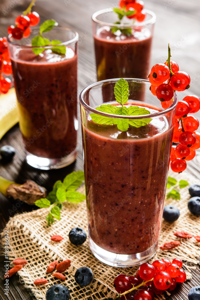 Fresh juicy smoothies with red currants, blueberry, banana, goji berries and chia seeds in a glass jar Fresh juicy smoothies with red currants, blueberry, banana, goji berries and chia seeds in a glass jar