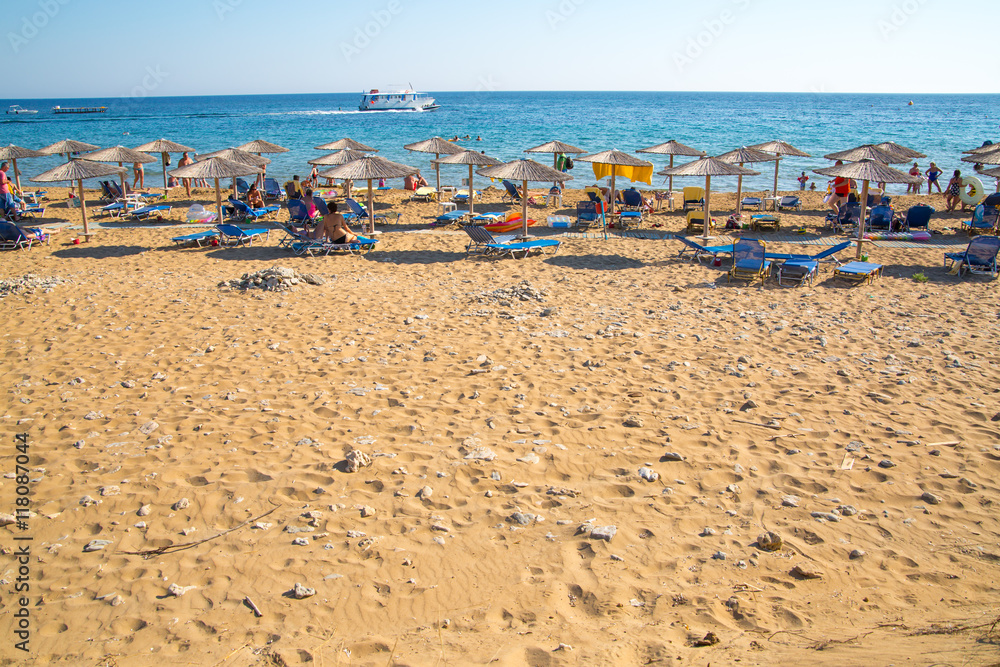 Blurred image of people relaxing under straw umbrellas at beach, Holiday concept