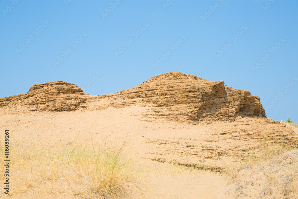 Rocks against of blue sky. Sandy beach of Corfu, Greece. 