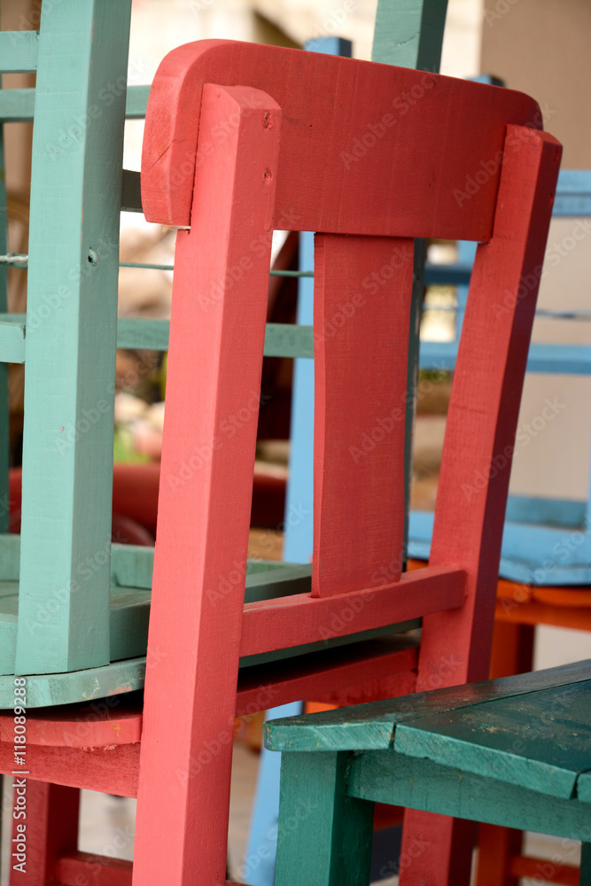 Piled up painted terrace chairs at the beach boulevard
