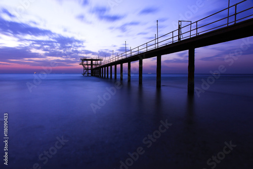 Harbor and Sea view on morning time before sunrise with silhouette fishing pier on foreground,Close up,select focus with shallow