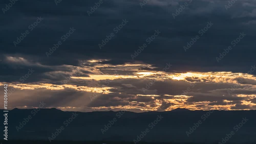 Time-lapse of Beautiful sunset scenery with Sun rays filtering through the clouds, casting a warm and enchanting glow on the hills of the valley. Time-lapse of Beautiful sunset scenery with Sun rays filtering through the clouds, casting a warm and enchanting glow on the hills of the valley.