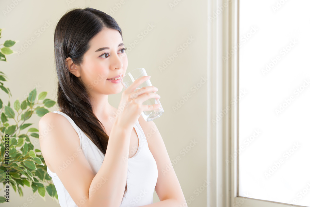 Beauty woman Drinking clean Water and looking out of window Beauty woman Drinking clean Water and looking out of window