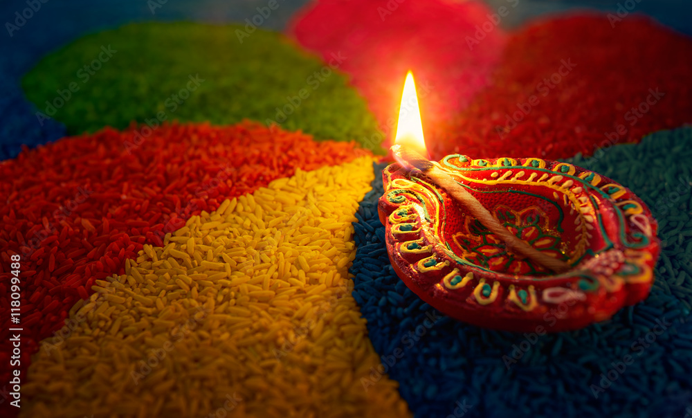 Diwali oil lamp - Diya lamp lit on colorful rangoli foto de Stock | Adobe  Stock
