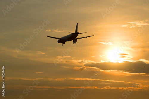 A passenger plane leaves in the evening sunset