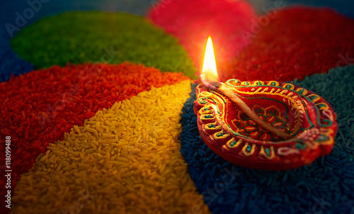 Diwali oil lamp - Diya lamp lit on colorful rangoli