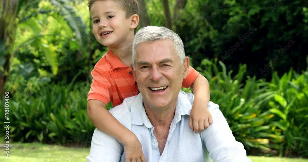 Mature man posing with his grandson in he garden Mature man posing with his grandson in he garden