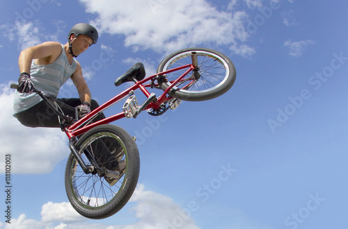 Extreme Sports BMX Rider against blue sky with clouds