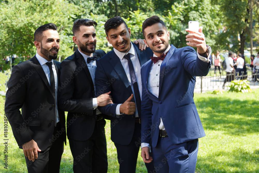 four young male friends with a cell phone four young male friends with a cell phone