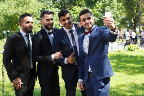 four young male friends with a cell phone