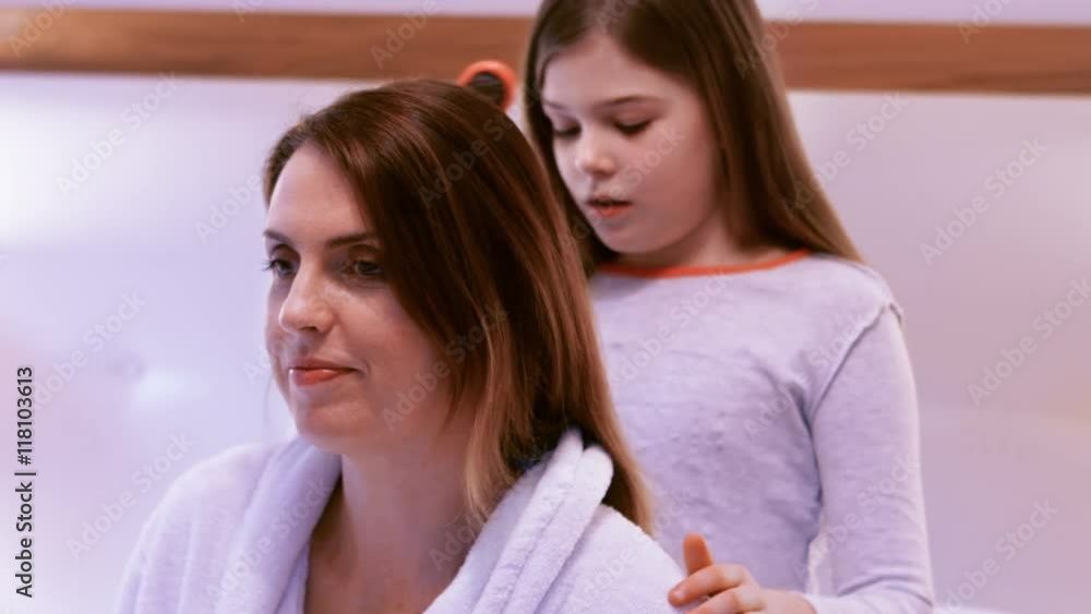 Daughter combing hair of mother in bed Daughter combing hair of mother in bed