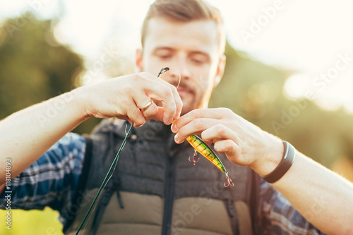 Fisherman with a spinning rod and bait (lure, wobbler) catching