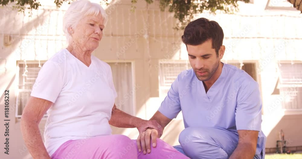 Male nurse assisting senior woman to exercise in the backyard Male nurse assisting senior woman to exercise in the backyard