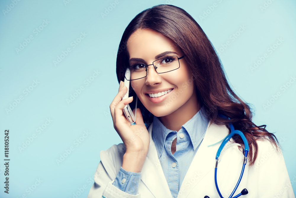 smiling young doctor with cellphone, on blue smiling young doctor with cellphone, on blue