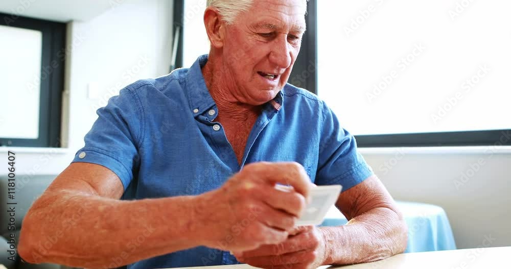 Retired man playing with cards in retired home Retired man playing with cards in retired home