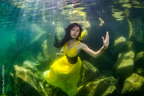 The girl in a dress under water