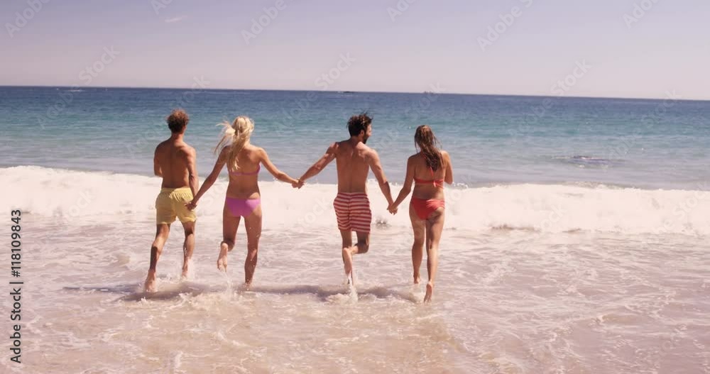 Friends running in the sea at beach Friends running in the sea at beach