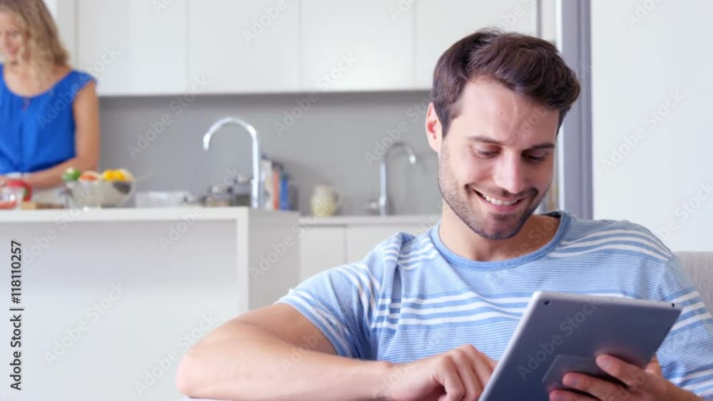 Woman cooking and man using tablet Woman cooking and man using tablet