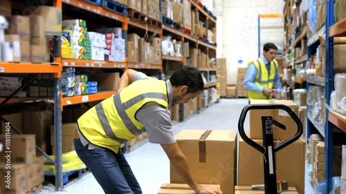 Worker with backache while lifting box