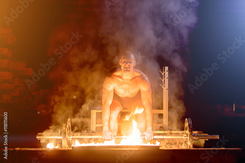 Athletically stacked man doing exercise with barbell that burns. Toning, noise photo