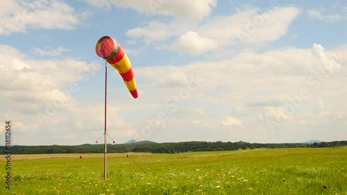 Summer hot day on sport airport with abandoned windsock, wind is blowing and windsock is moving photo