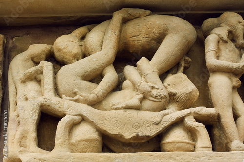 Photography Couple in love having sex on stone relief of famous Khajuraho temple, India