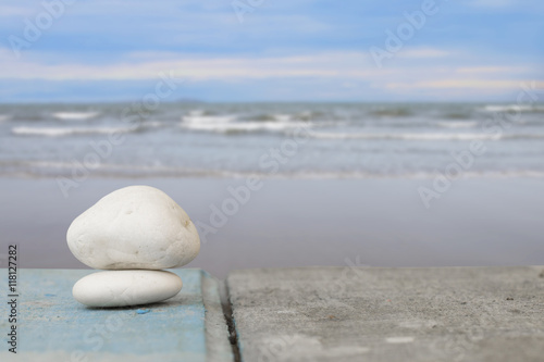 pebbles on the wooden with sea and beach background.