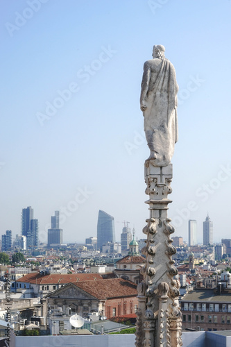 white marble sculpture of a roman man back on rooftop of famous Cathedral Duomo di Milano on piazza in Milan, Italy. Concept of Ancient Roman looking back on the past and loneliness.