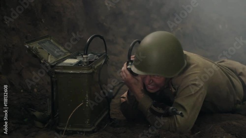 Soviet soldier during combat action crawls to portable radio.